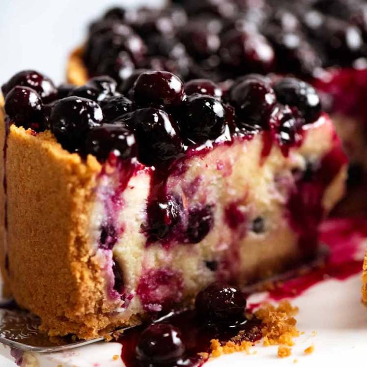 Close up of slice of Blueberry Cheesecake with drip of Blueberry Sauce