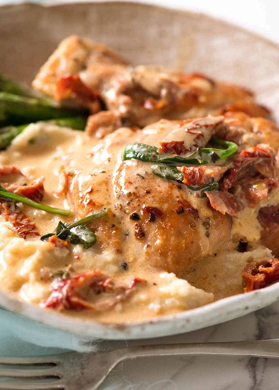 Close up of Chicken with creamy sauce with sun dried tomatoes, served on mashed potato, ready to be eaten