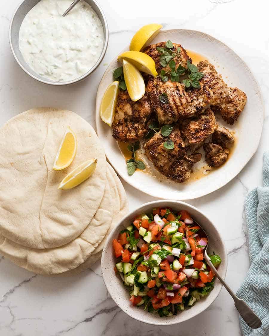 Photo of the components of Greek Chicken Gryos - marinated Greek Chicken, tzatziki and tomato cucumber salad.
