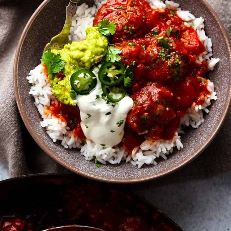 Overhead photo of Mexican Meatballs served with guacamole and sour cream over rice