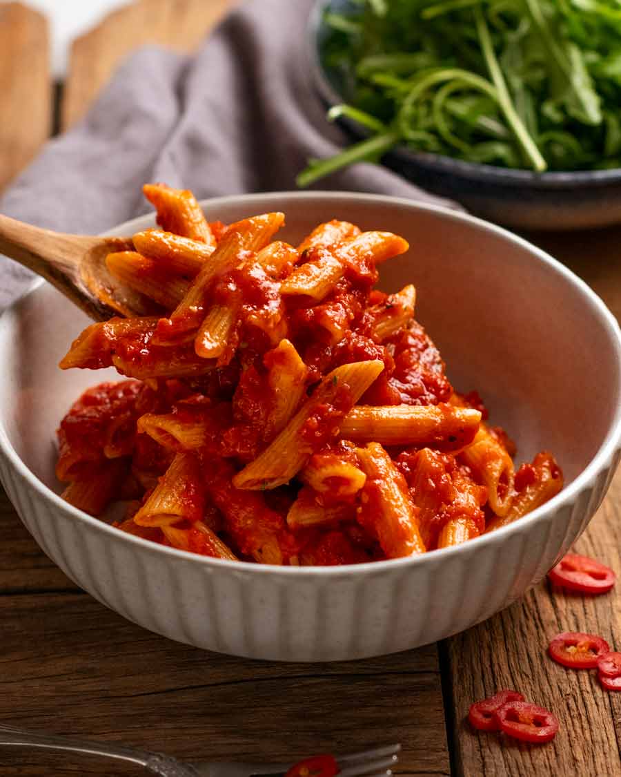 Serving Penne all'arrabbiata (spicy tomato pasta)